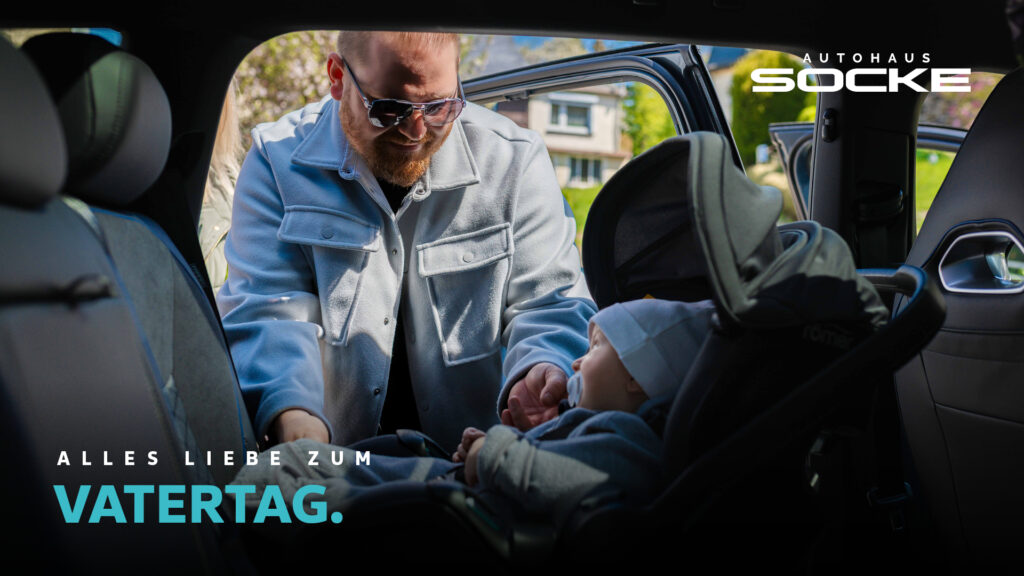 Ein Mann schaut lächelt zu seinem Kind im Auto