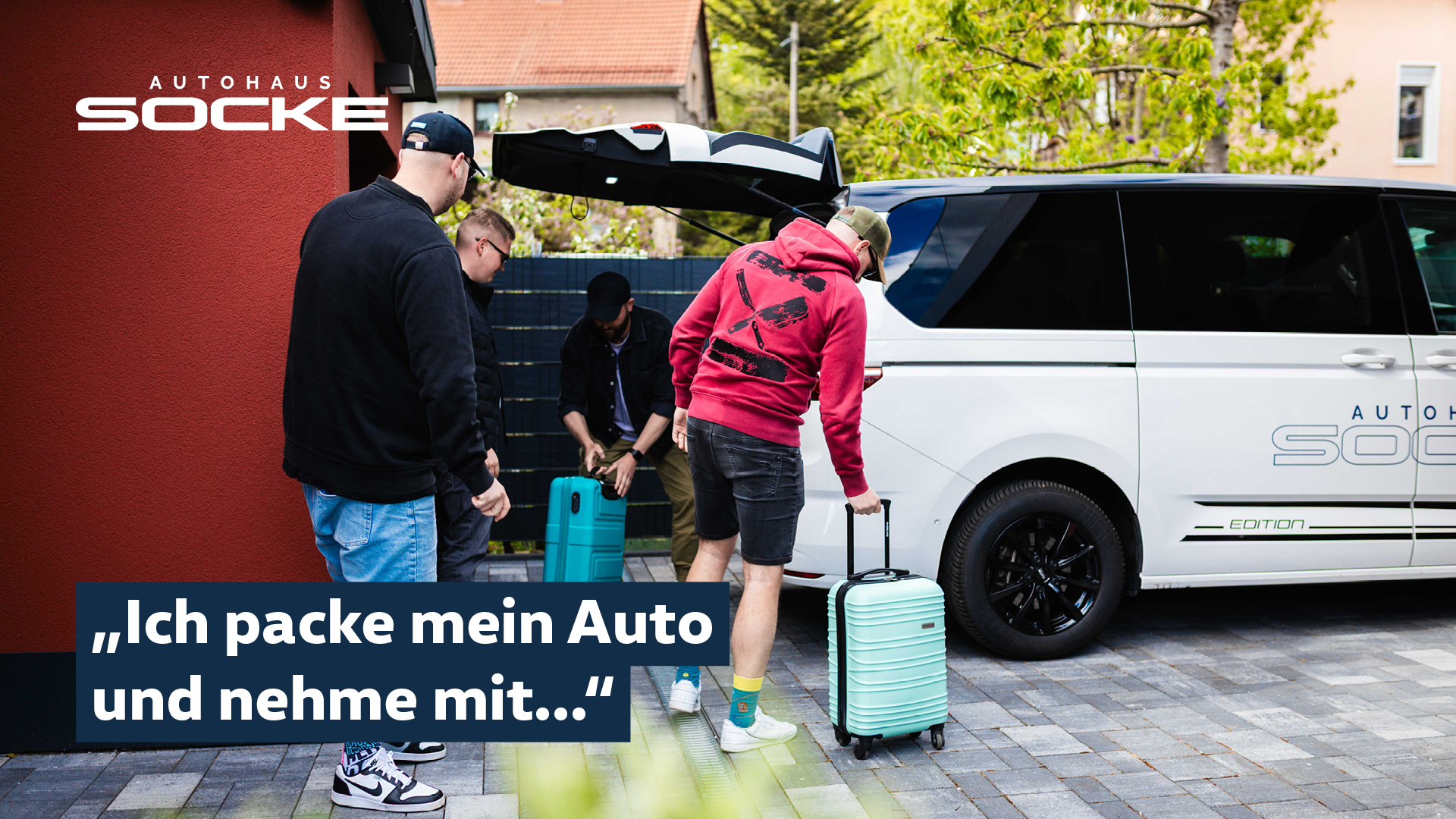 Vier Männer verstauen Koffer in einem Multivan Kofferraum
