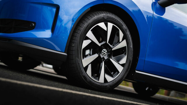 Nahaufnahme der zweifarbigen Leichtmetallfelge mit Bridgestone-Bereifung an einem blauen Volkswagen ID. POLO.