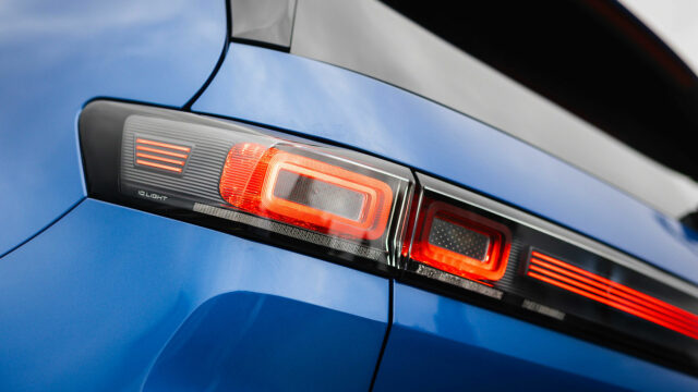 Detailaufnahme der IQ.Light LED-Rückleuchte an der blauen Karosserie mit leuchtender Lichtsignatur.