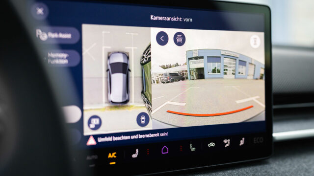 Infotainment-Display im Innenraum mit aktiver Ansicht des Parkassistenten und der Frontkamera.