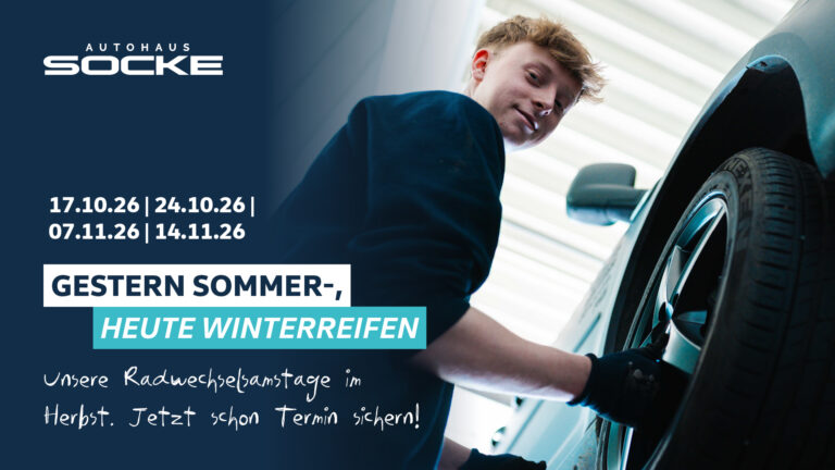 Radwechseltermine bei Autohaus Socke. Junger Werkstattmitarbeiter welchselt einen Rad an einem Auto